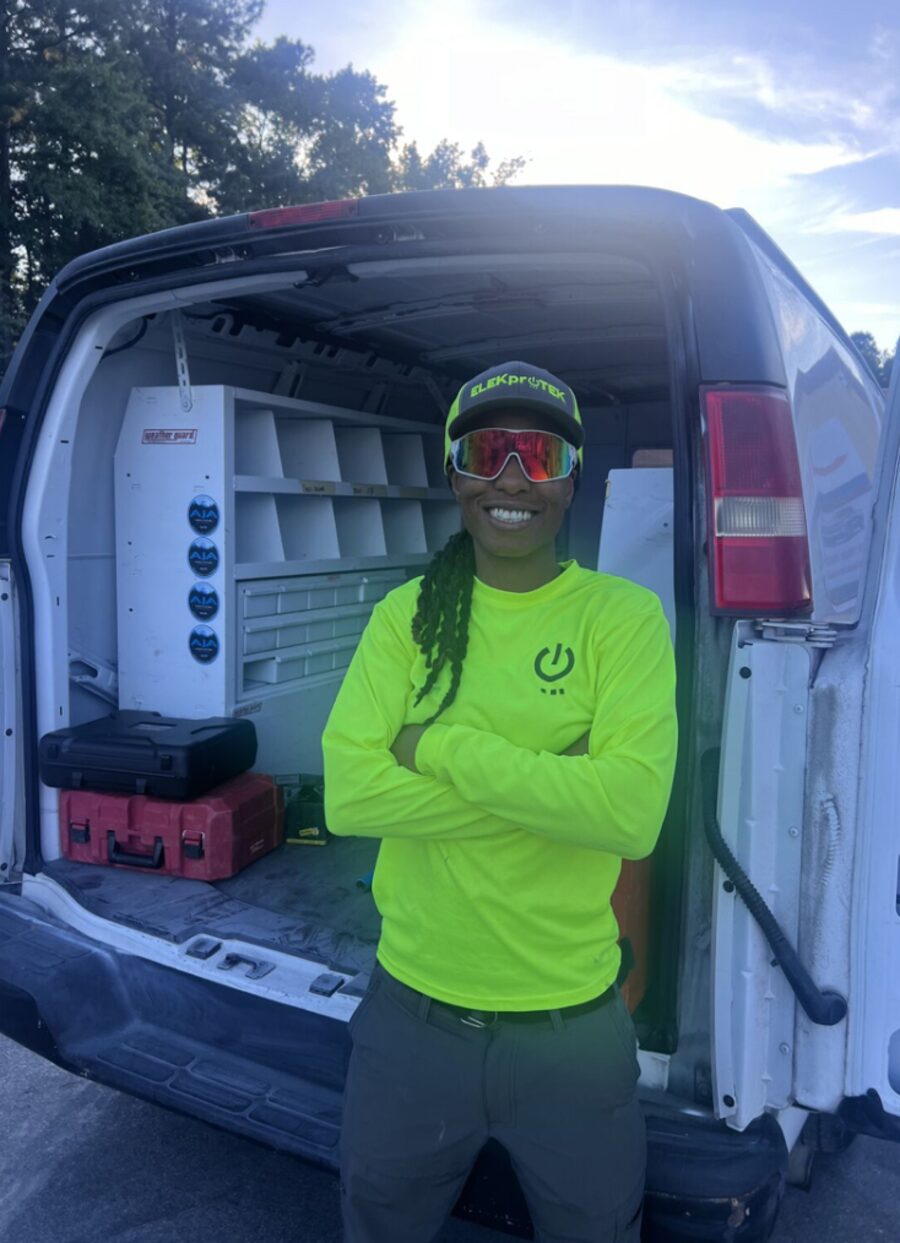 ELEKproTEK team member standing at fully equipped service van with organized tool storage