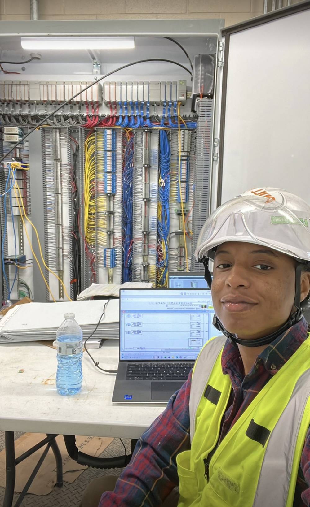 ELEKproTEK controls engineer programming PLC ladder logic on laptop in front of industrial control panel wiring, Charleston SC