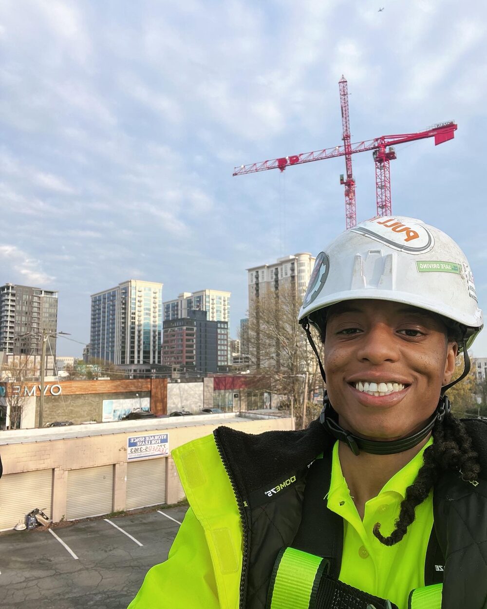 ELEKproTEK team member on jobsite rooftop with city skyline in the background