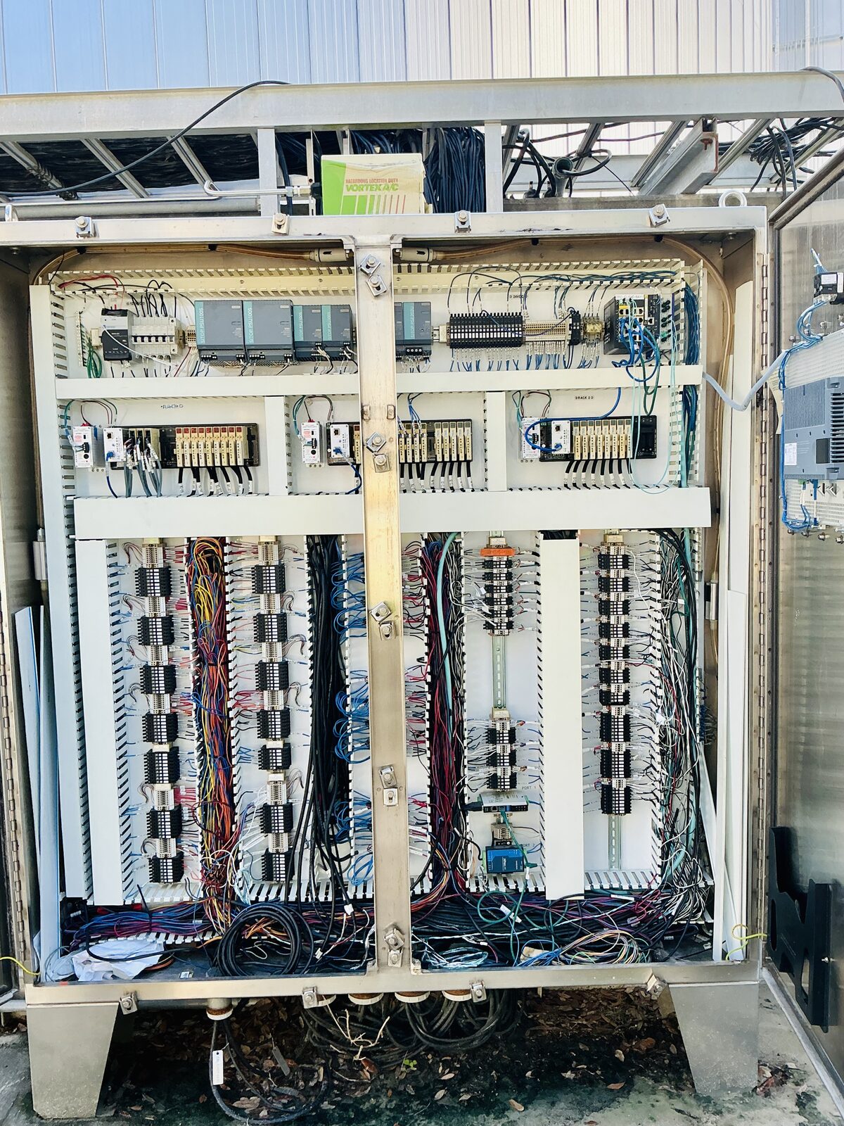 Open stainless-steel field control enclosure with power supplies, Opto 22 I/O racks and labeled terminal blocks