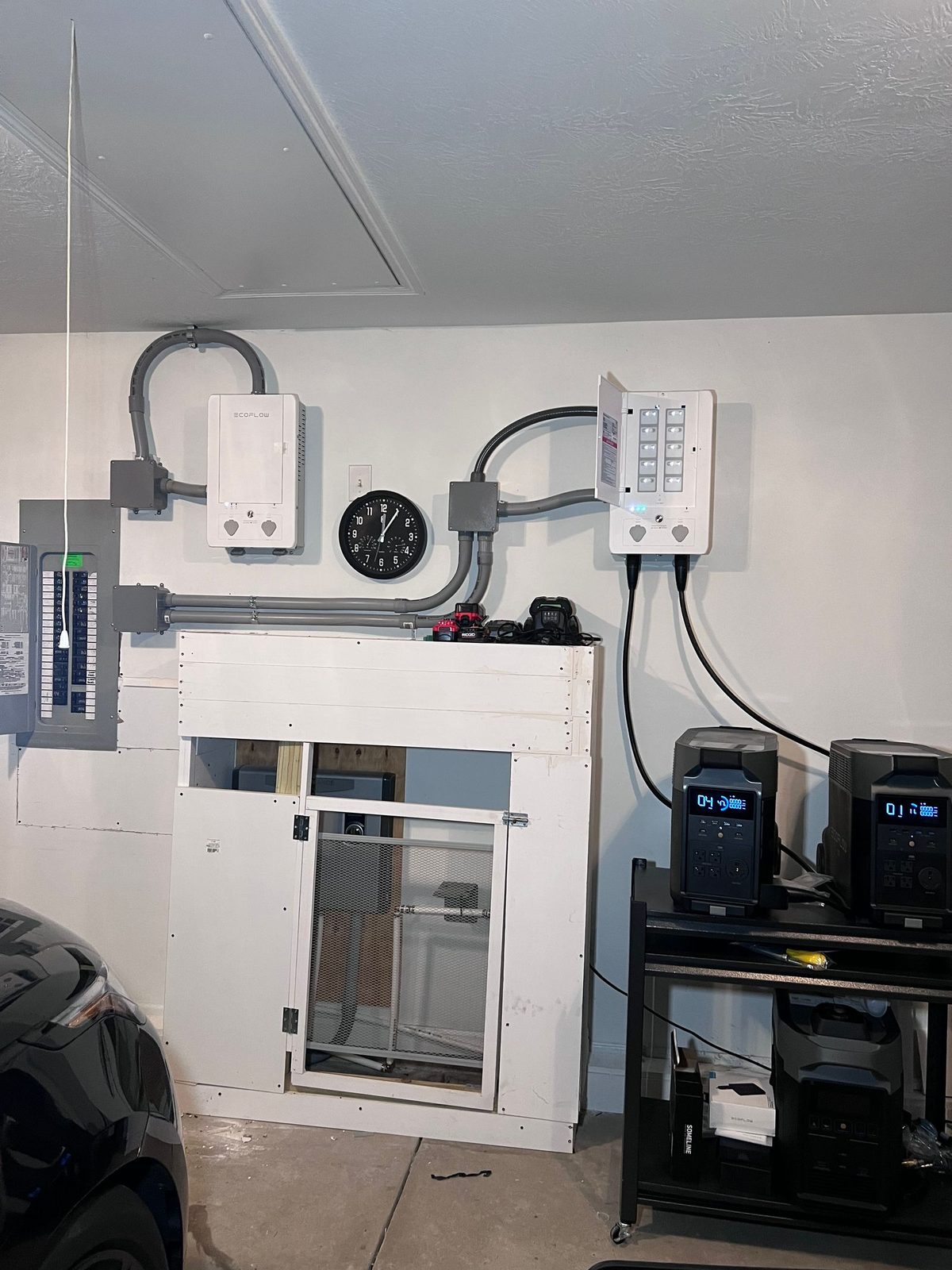 Garage wall with a small panel, transfer equipment, and two portable power units on a stand